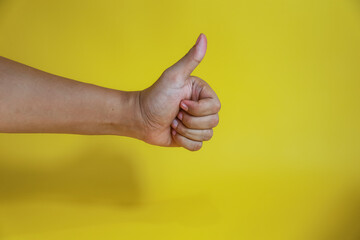 hand with thumb up isolated on yellow background with copy space, concept Admiration, Excellen