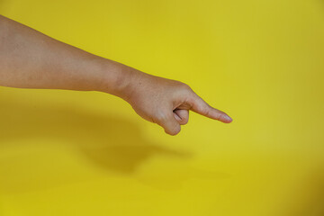 hand pointing on virtual object with index finger, making gesture, isolated on yellow background