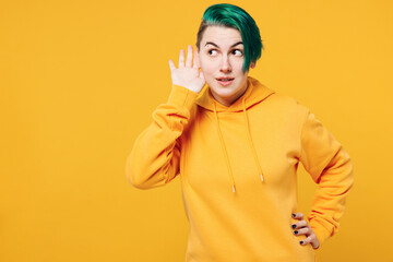 Young curious nosy happy woman with dyed green hair wear hoody casual clothes try to hear you...
