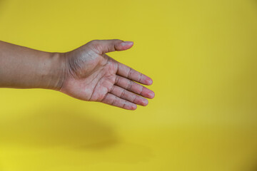 hand giving a greeting gesture isolated on yellow background