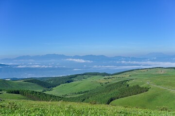 車山高原から見た山並みとグリーンに包まれたドライブウェイのコラボ情景