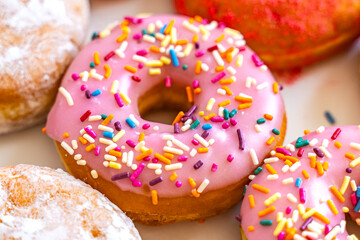Close-up of a pink donut with glazing in a box. Various donuts in a box. 