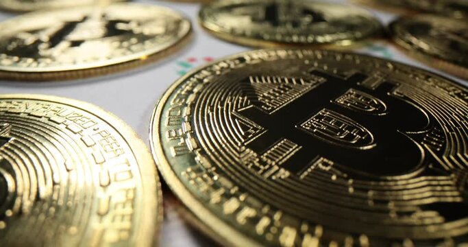 Closeup of bitcoin cryptocurrency gold coins with red and green graph