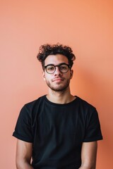 Obraz premium A man with glasses and a beard is wearing a black shirt