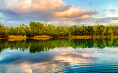 A tranquil lake surrounded by lush greenery, with vibrant water reflecting a dramatic sky a serene...