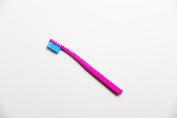 Hand toothbrush on a white background. Bright pink brush for cleaning teeth, top view