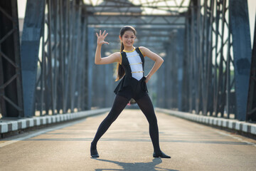 Beautiful girl ballerina dancing. Ballerina Performance Street Show in the city. A teenager poses...