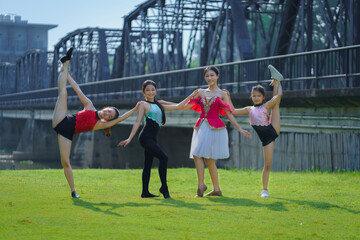 Beautiful Asian girl performs an acrobatic pose. Performance Street Show in the city. A teenager poses as an aerobatic performer at a tourist attraction, in Chiang Mai, Thailand.