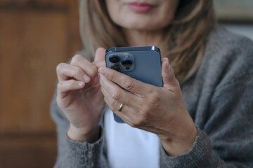 hands of woman using mobile phones reading, watching at home 