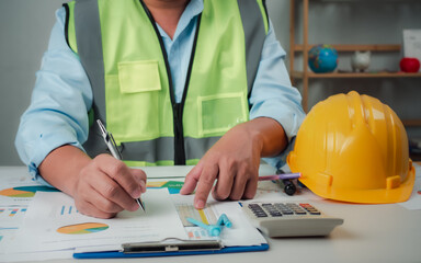 A foreman sits at a desk in an office, Calculating costs, Planning construction, Calculating structures, Planning and calculating project construction costs, Project presentation plan.