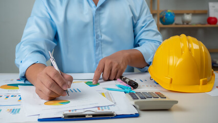 Architect or engineer sitting at desk in office, Cost calculation, Construction planning, structural calculation, Project construction cost planning and calculation, Project presentation plan.