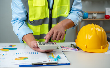 A foreman sits at a desk in an office, Calculating costs, Planning construction, Calculating structures, Planning and calculating project construction costs, Project presentation plan.