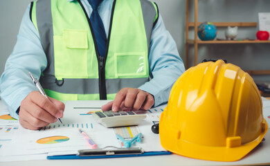 Architect or engineer sitting at desk in office, Cost calculation, Construction planning, structural calculation, Project construction cost planning and calculation, Project presentation plan.