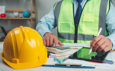 Architect or engineer using tablet to work on table, cost calculation, construction planning, structural calculation, construction cost planning, structural design, project presentation plan.