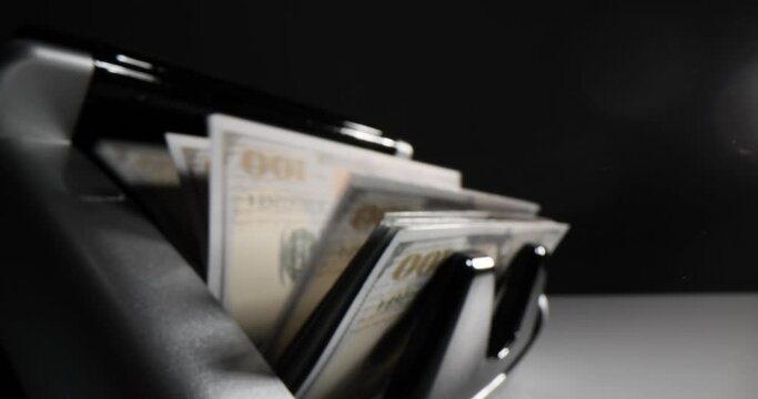 Money counting machine counts bundle of dollar banknotes