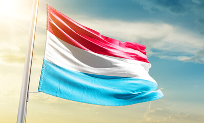 Luxembourg national flag waving in beautiful sky.