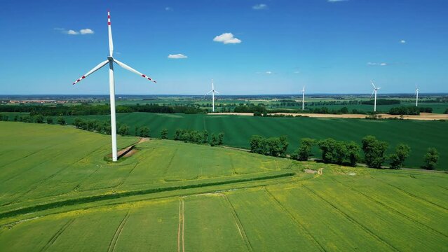 Wind farm generating clean renewable electrical energy. Alternative green energy, ecological industry. Aerial view. 4k footage.