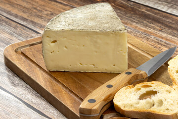 fromage : tomme de Savoie, en gros plan, sur une table	