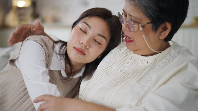 Middle-aged Asian mother listens to her daughter's problems and encourages her with love and care in Livingroom at home.