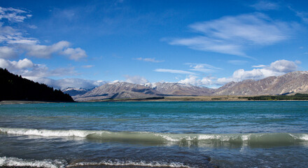 Lake Tekapo from the shoreline looking over to the other side. The colour of the water is produced when fine silt is washed into the lake from the melting of the snowcaps.