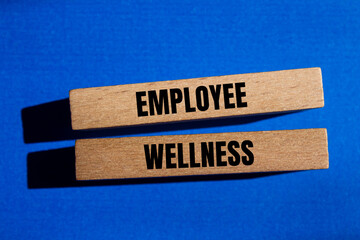 Employee wellness words written on wooden blocks with blue background. Conceptual employee wellness...