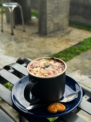 Tasty hot chocolate topped with burnt cream on a coffee shop table in the park