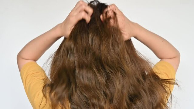 Rear view of young woman scratching her scalp caused of itchy scalp.