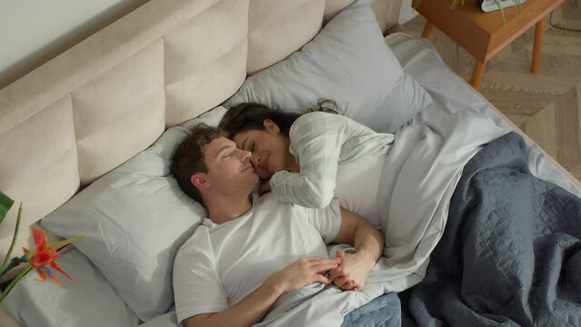 Couple love man woman sleep on bed bedroom home cosy wake up together happiness weekend rest daydream napping soft mattress warm apartment tenderness sweetheart intimacy cuddle harmony marriage warmth