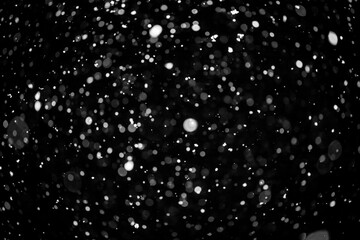  Bokeh lights on black background, shot of flying snowflakes in the air