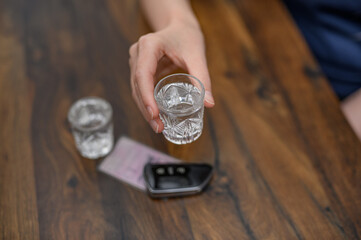 Jazda po alkoholu, pić wódkę, obok leżą kluczyki do auta i dokument prawo jazdy © Paweł Kacperek