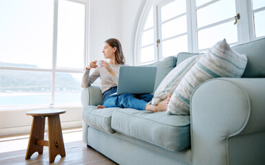 Woman, laptop and coffee for thinking in home, freelancer and online for copywriter research on sofa. Female person, relax and drinking espresso on couch, ponder and website for planning or email