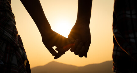 Friendship, Love and Valentine day concept. A couple holding hand during sunset, a symbol of love and happy relationship.
