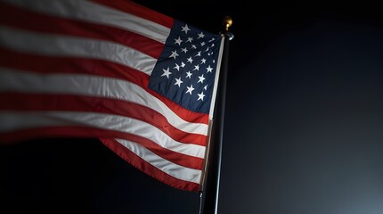 Close up of american flag flowing at night, with a background of blurred lights in the city