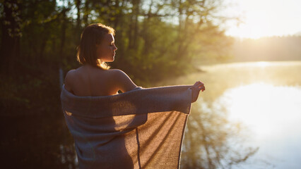 A young attractive woman enjoy sunrise on the water in beautiful nature. In healthy body - healthy...