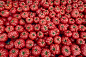 Clean eating concept. Bunch of ripe juicy freshly picked organic tomatoes in pile at local produce farmers market. Healthy diet for spring summer detox. Vegan raw food. Close up, background.