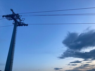 Ski lift against the backdrop of an ultramarine evening sky. Cable car pole with free space for...