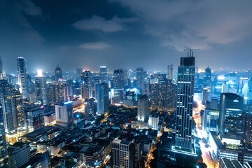 Naklejka premium City Skyline at Night: Aerial View of Illuminated Skyscrapers