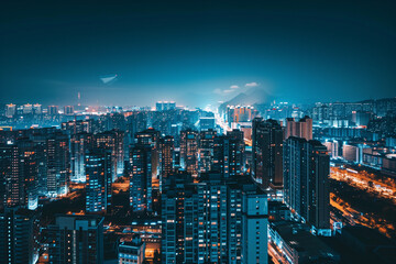 Fototapeta premium City Skyline at Night: Aerial View of Illuminated Skyscrapers