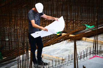 Architekt kontrolliert Bauplan auf Baustelle