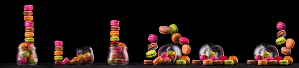 Jar of french colorful macaroon or macaron on wooden table isolated on black