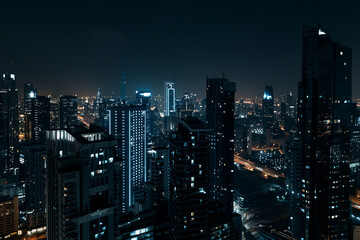Fototapeta premium City Skyline at Night: Aerial View of Illuminated Skyscrapers