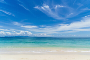 Obraz premium Sunlit Beach with Blue Sky and Ocean View