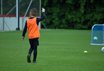 Boy in an orange T -shirt on a football field