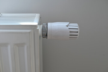 A white radiator against a grey wall.