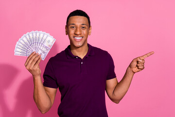 Photo portrait of attractive young man hold money fan point empty space dressed stylish violet...
