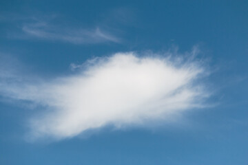 Blue sky with single white cloud burst shape background