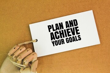 wooden hand and white paper with the words plan and achieve your goals