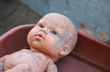 discarded dirty doll baby without clothes