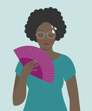 Woman cooling herself with fan, menopause symptoms, hot flashes.