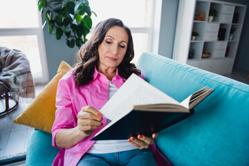 Photo of lovely adorable retired woman sitting couch reading book story weekend time comfort indoors